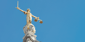 A statue of Lady Justice holding a sword and balancing scales, on top of the Old Bailey, England's criminal court in the City of London, officially called the Central Criminal Court.