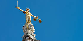 A statue of Lady Justice holding a sword and balancing scales, on top of the Old Bailey, England's criminal court in the City of London, officially called the Central Criminal Court.
