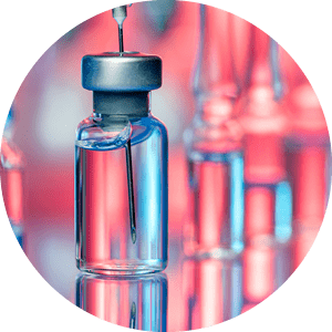 Close up shot of vaccines - glass bottles, ampules and syringe with needle. Good for illustration of flu shot, vaccination and covid-19