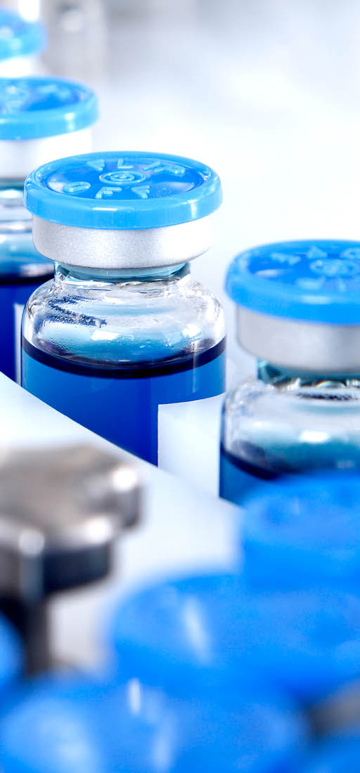 Glass bottles in production in the tray of an automatic liquid dispenser, a line for filling medicines against bacteria and viruses, antibiotics and vaccines